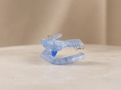 A custom oral appliance for sleep apnea, worn over the teeth to hold the lower jaw forward